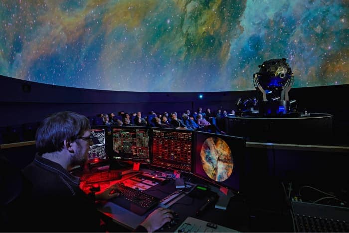 The audience during a screening and a little peek behind the screen of the planetarium staff.